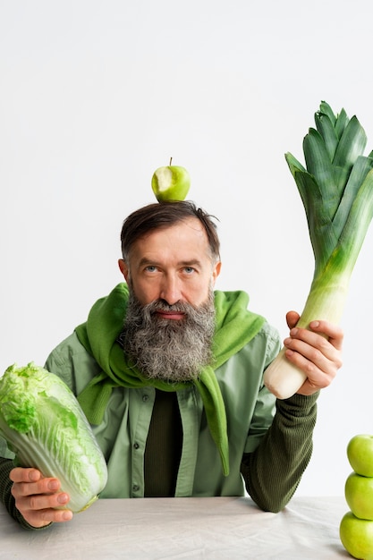 Hombre de mediana edad posando con apio