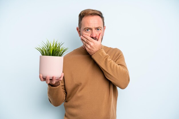 Hombre de mediana edad que cubre la boca con las manos con un concepto de maceta conmocionado