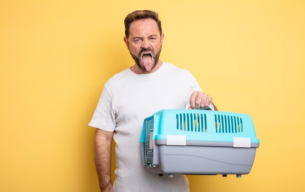 Hombre de mediana edad que se siente disgustado e irritado y saca la lengua del concepto de portador de mascotas