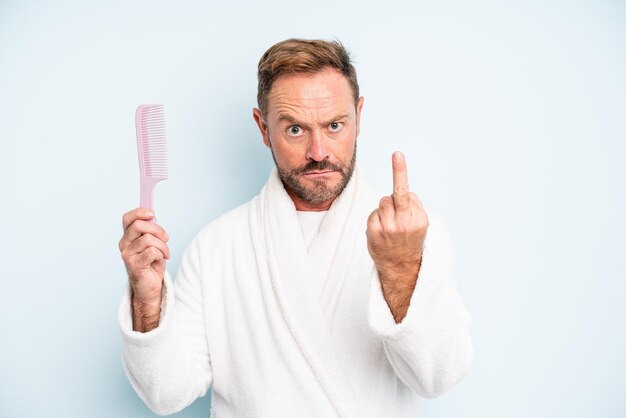 Hombre de mediana edad que se siente enojado, molesto, rebelde y agresivo. concepto de peine para el cabello