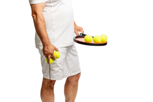 Hombre de mediana edad con raqueta y pelotas de tenis. Aislado en un fondo blanco.