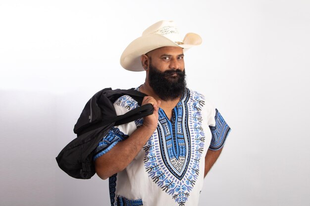 Hombre de mediana edad saludable indio vistiendo gorra de vaquero y camiseta de Hawai y sosteniendo la bolsa