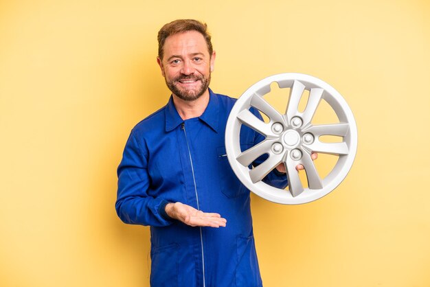 Hombre de mediana edad sonriendo alegremente sintiéndose feliz y mostrando un concepto de mecánico de automóviles