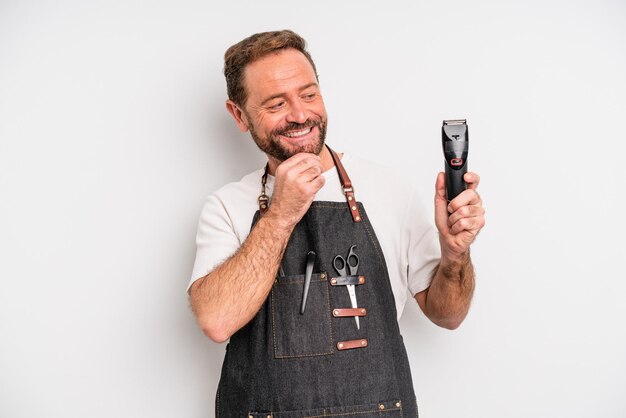 hombre de mediana edad sonriendo con una expresión feliz y segura con la mano en la barbilla. concepto de barbero