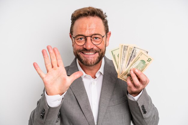 Hombre de mediana edad sonriendo y luciendo amigable mostrando el concepto de billetes de cinco dólares