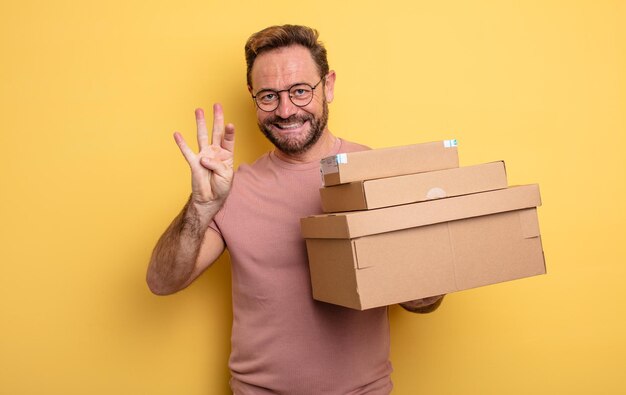 Hombre de mediana edad sonriendo y luciendo amigable mostrando el concepto de cajas de paquetes número cuatro