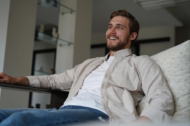Hombre de mediana edad teniendo un momento de descanso relajándose en el sofá