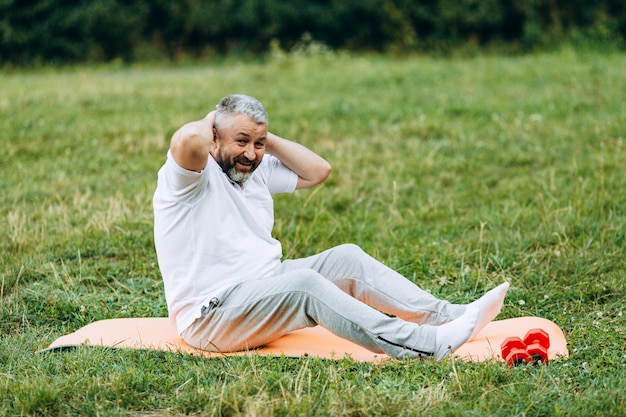 Hombre de mediana edad tomando ejercicios para los abdominales al aire libre. deporte