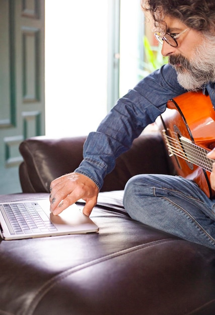 Hombre de mediana edad tomando lecciones de guitarra en casa