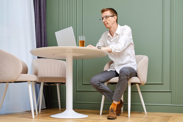Hombre de mediana edad usando una computadora portátil en casa sentado en la sala de estar