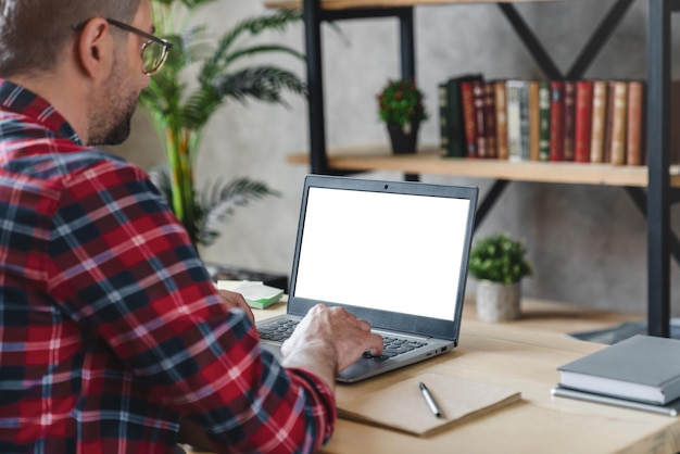 Hombre de mediana edad usando una pantalla en blanco de imagen de maqueta de computadora con fondo blanco para publicidad