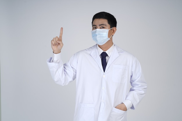 Hombre médico asiático en máscara médica, dedo acusador