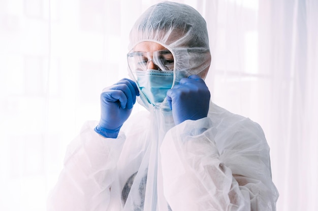 Hombre médico o científico con traje protector y mascarilla