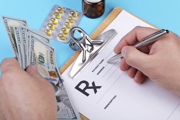 Foto hombre médico o farmacéutico con dinero en mano y escribir la receta en un formulario especial.