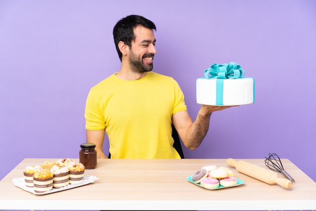 Hombre en una mesa con un gran pastel