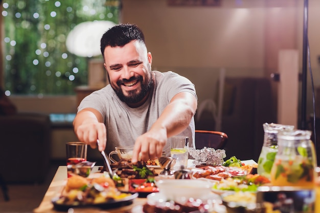 Hombre en la mesa grande con comida.