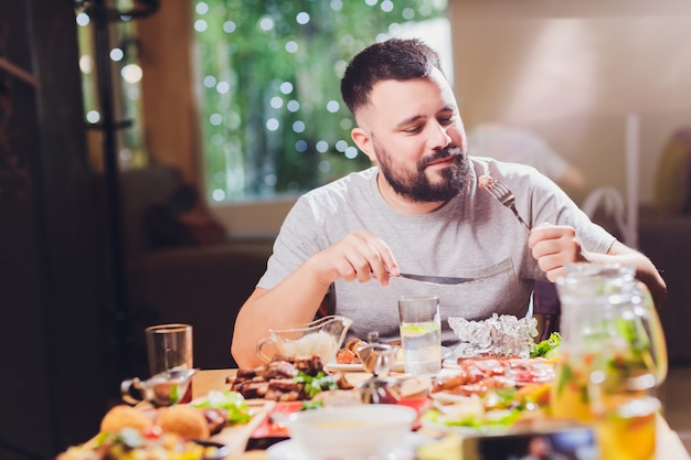 Hombre en la mesa grande con comida.