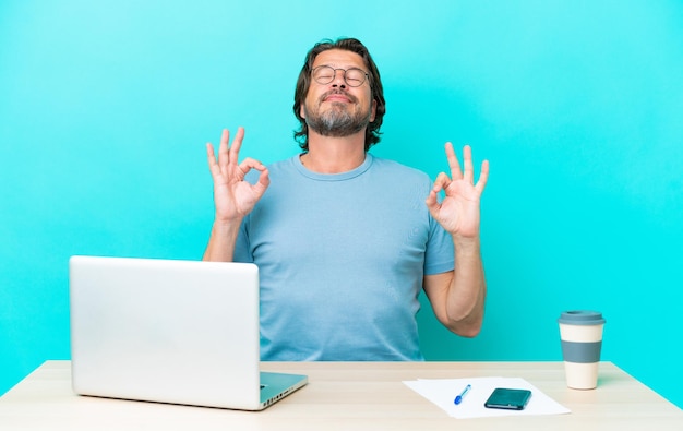 hombre en la mesa sobre un fondo azul aislado