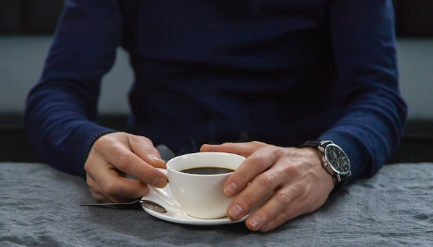 Un hombre en la mesa con una taza de café.