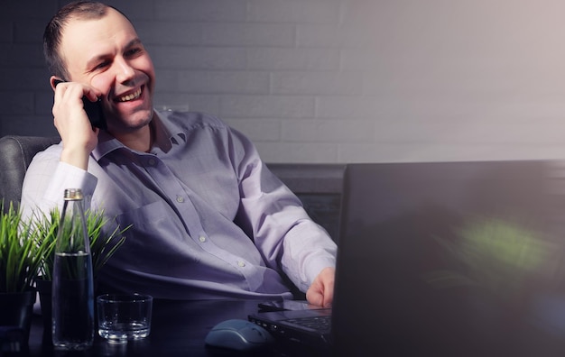 Hombre en la mesa y trabajando en la computadora portátil