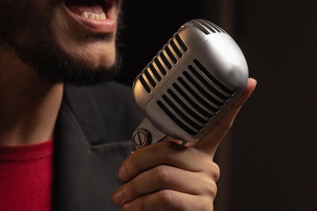 Un hombre con un micrófono en la mano está cantando en un micrófono.