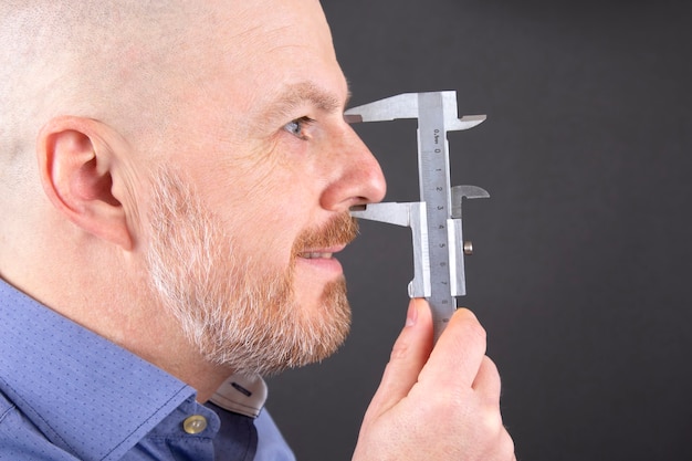 El hombre mide el tamaño de la pinza del dispositivo de medición de la nariz