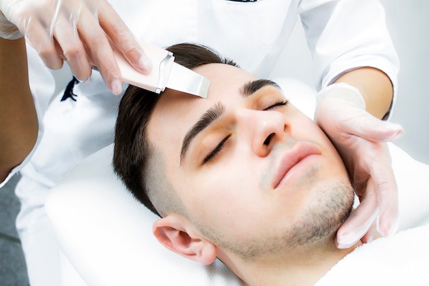 Un hombre miente sobre el procedimiento para limpiarse la cara con acné con los ojos cerrados.