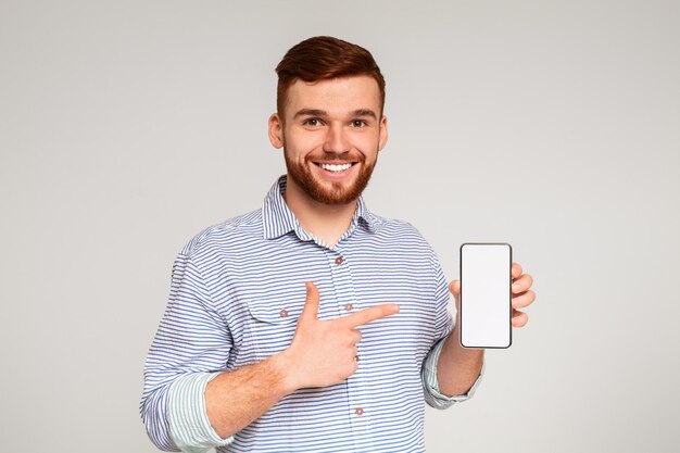 Foto un hombre del milenio sonriente sosteniendo el último teléfono móvil delgado