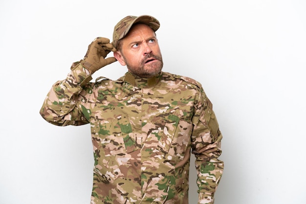 Hombre militar aislado de fondo blanco que tiene dudas y con expresión facial confusa
