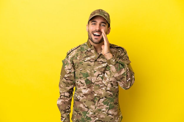 Hombre militar aislado sobre fondo amarillo gritando con la boca abierta