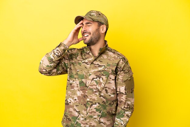 Hombre militar aislado sobre fondo amarillo se ha dado cuenta de algo y tiene la intención de la solución