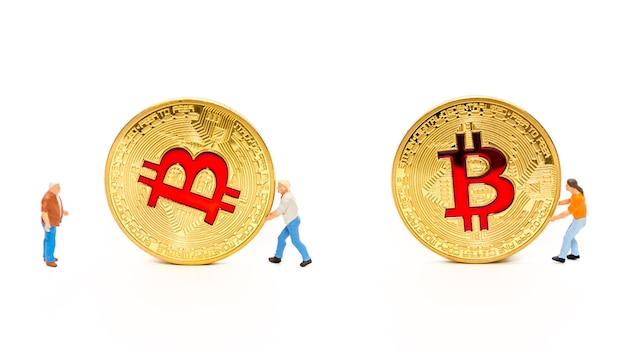 hombre en miniatura rodando moneda de oro de bitcoin