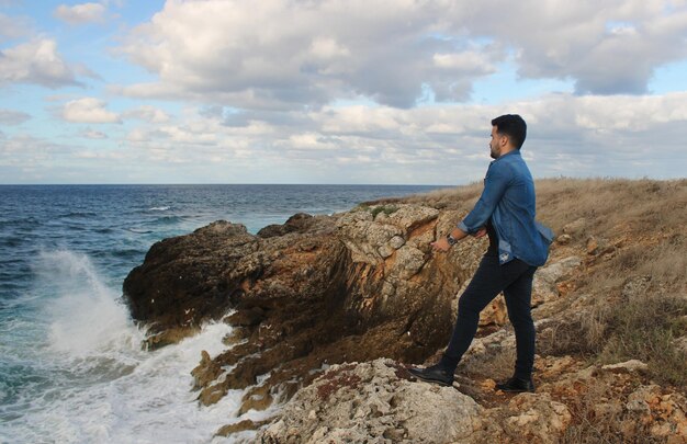 El hombre mira al mar desde la zona costera