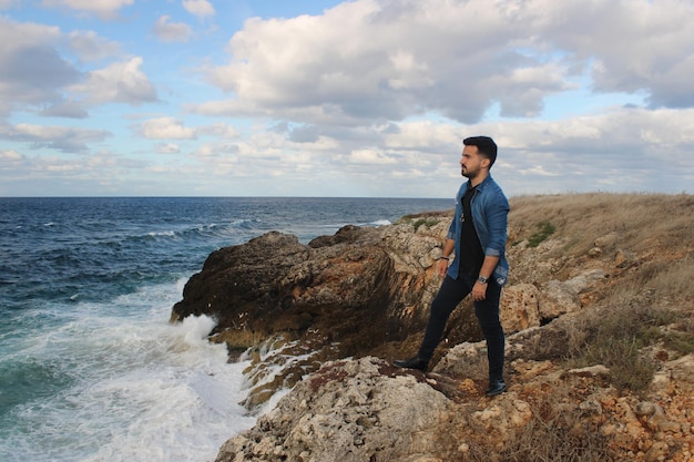 El hombre mira al mar desde la zona costera