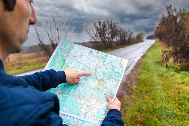 Foto un hombre mira un mapa en el camino enfoque selectivo