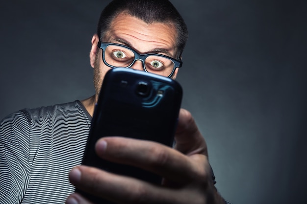 El hombre mira su teléfono inteligente