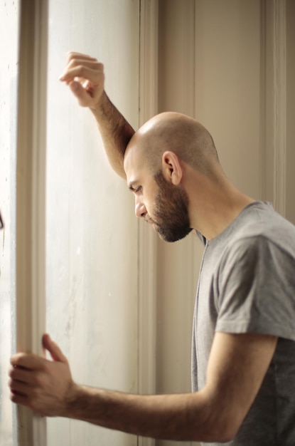 Foto el hombre mira por la ventana