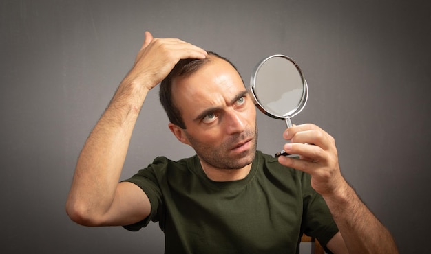 Hombre mirando al espejo Concepto de pérdida de cabello