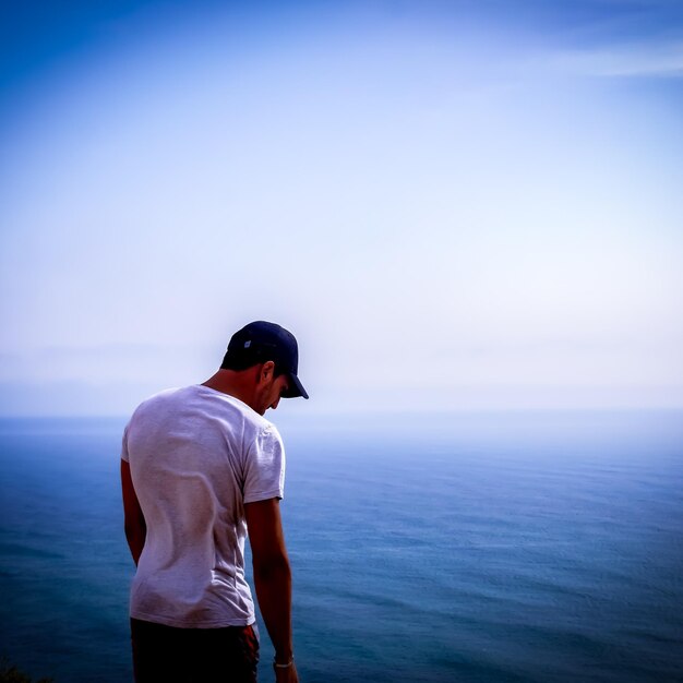 Hombre mirando al mar contra el cielo