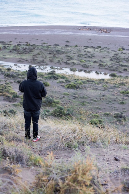 Hombre mirando el amanecer en la playa patagonia de lobos marinos