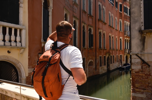 Hombre mirando en las calles de Italia, Venecia, casas antiguas. Calles y canales de Venecia. Vista a la calle en Venecia, Italia. Hombre turista viaje en Italia, Venecia.