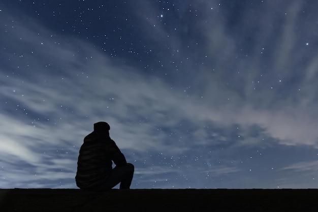 Hombre mirando las estrellas. Hombre solo mirando el cielo estrellado. Cielo nocturno.