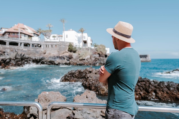 Hombre mirando el horizonte en la playa