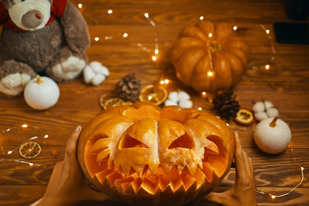 Hombre mirando en la linterna de calabaza naranja de Jack para las tradicionales vacaciones de otoño Halloween.