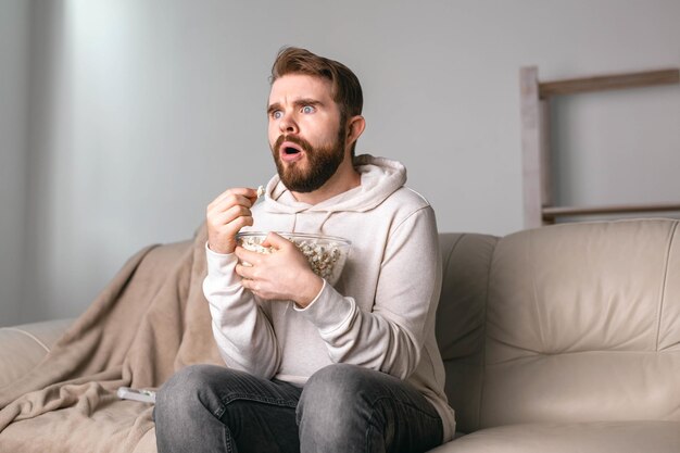 Foto hombre mirando hacia otro lado mientras está sentado en el sofá en casa