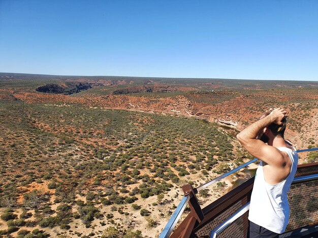 Foto hombre mirando el paisaje contra el cielo azul claro