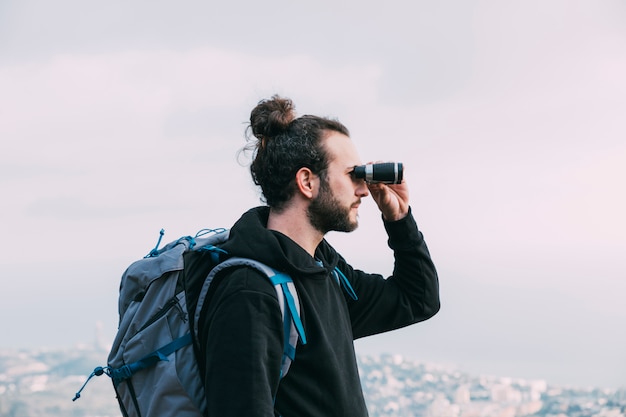 Foto hombre mirando por prismáticos