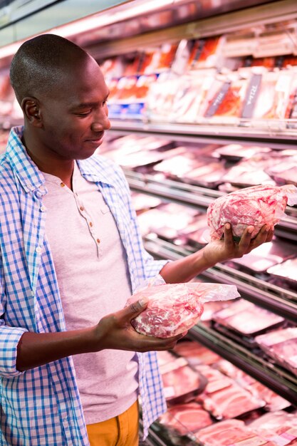 Hombre mirando productos en la sección de comestibles mientras compras