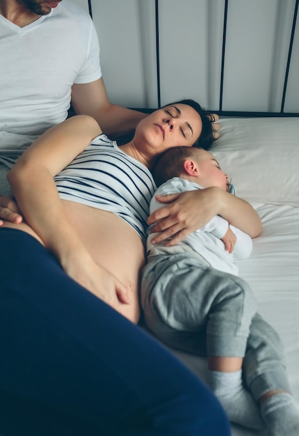 Hombre mirando a su esposa e hijo durmiendo