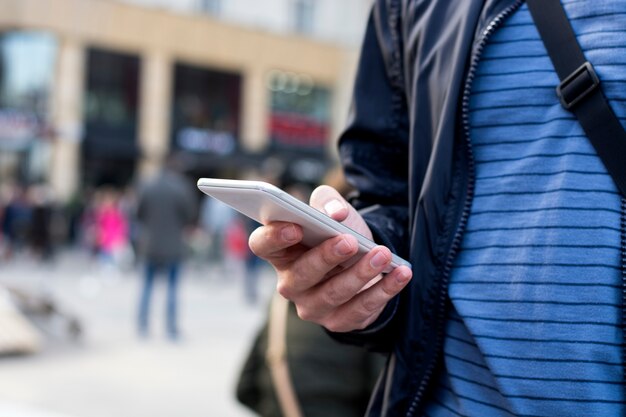 Hombre mirando su teléfono en la calle de la ciudad